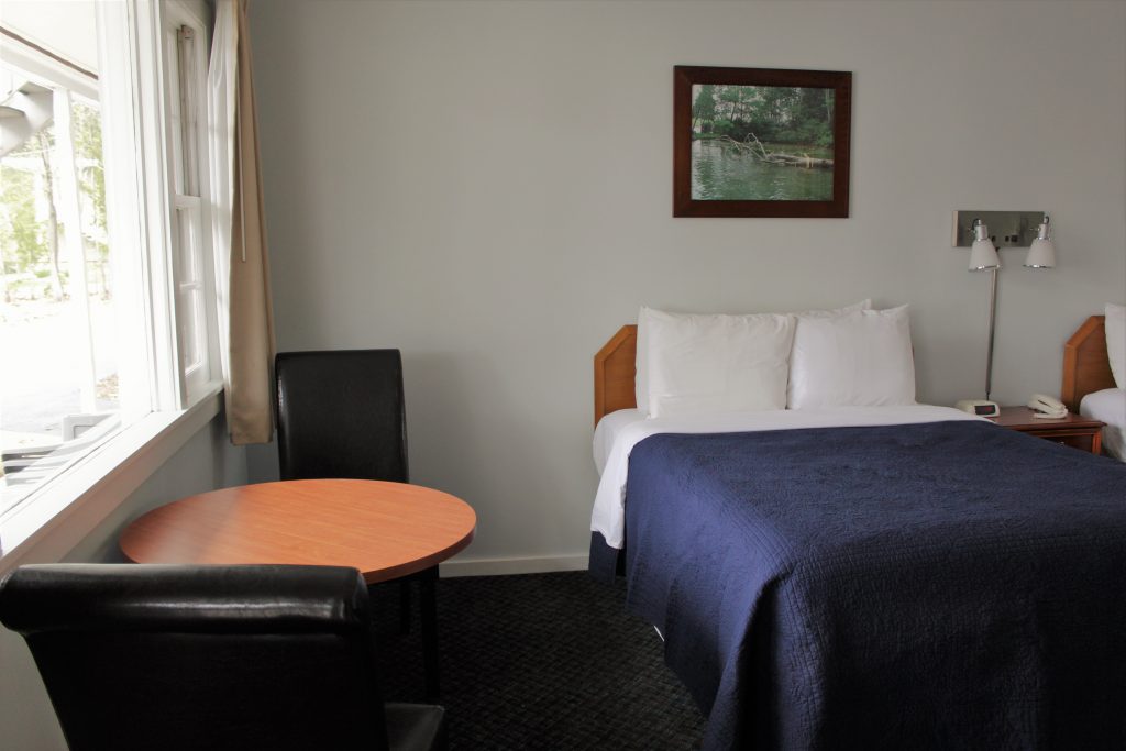 twin bed next to small tables and chairs