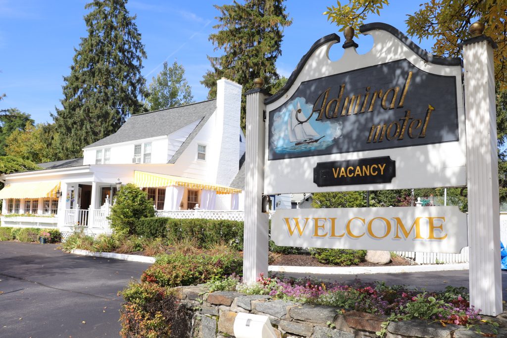 Welcome to The Admiral Motel sign in front of office